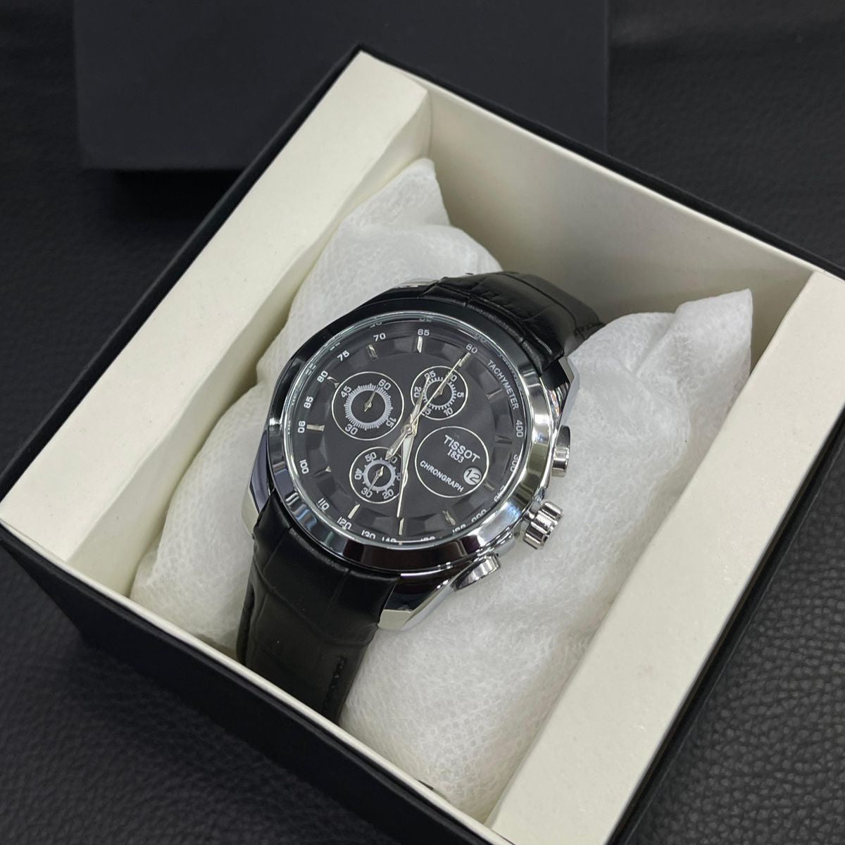 Tissot watch in a box with Tissot logo in the background